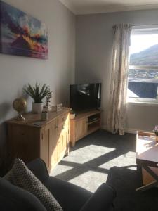 波特里4 York Drive, Portree , Isle Of Skye的客厅配有电视、沙发和窗户。