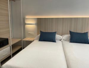 阿利坎特LC Hotel Urbano的两张带蓝色枕头的床