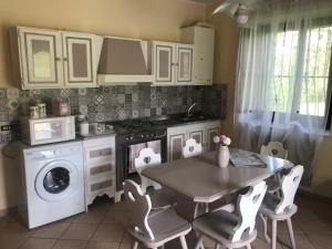 RoccamoriceVal Giardino Vintage Cottage的厨房配有桌子、炉灶和洗衣机。