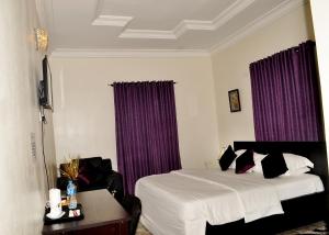 拉各斯J Gibson Hotel的配有床和紫色窗帘的酒店客房