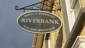勒兰蒂德威尔斯Riverbank Bed and Breakfast的建筑物一侧河岸的标志