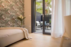 里乔内RICCIONE SUITE DESIGN的一间卧室设有一张床和一个滑动玻璃门