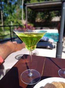 图卢姆Xaha Villas Suites & Golf Resort的桌上一杯马提尼酒中的绿色饮料