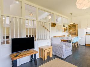 霍普湾2 Brook Cottages的客厅配有平面电视和桌子。