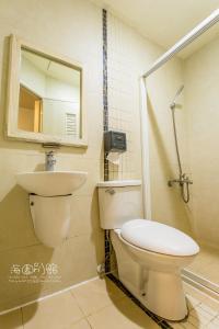 垦丁大街墾丁海園別館Hai Yuan Inn的一间带卫生间、水槽和镜子的浴室