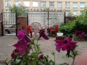 圣彼得堡姆米特罗利旅舍的庭院配有桌椅和紫色鲜花