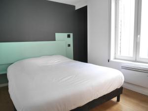 里尔查韦多特公寓的卧室内的一张白色床,设有窗户