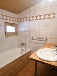 萨莫安斯格兰格斯公寓式酒店的浴室配有盥洗盆和浴缸。