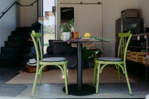 亚林加普Barn Hives Yallingup的客厅配有一张桌子和两把绿色椅子