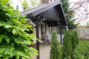 巴洛泰什蒂Casuta Bradulet - Aeroport Otopeni & Therme的花园里有黑色遮阳篷的小房子