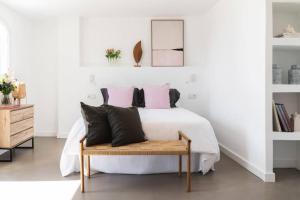 马贝拉Las Flores de Marta (Milla de Oro - Marbella)的卧室配有白色床和粉色及黑色枕头。