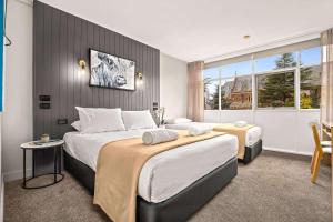 阿米代尔City Centre Motel Armidale的酒店客房设有两张床和窗户。
