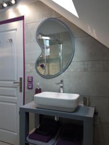 Épeigné-les-BoisGîte Les Nymphéas的浴室设有白色水槽和镜子