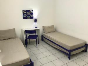 巴拉奈里奥-坎布里乌Apartamento Confortavel em Balneário Camboriu的一间设有两张床、一张桌子和一把椅子的房间