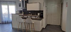 豪伊杜索博斯洛IKON apartman的厨房配有2张吧台凳和1个柜台。