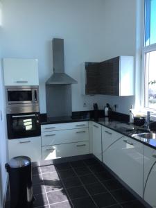 贝德福德Sky View Apartment with Terrace的厨房配有白色橱柜和炉灶烤箱。