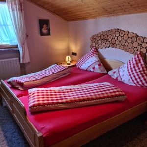容霍尔茨Haus Cornelia的一间卧室配有两张红色床单