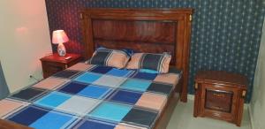 Mbaw Gou NdawAppartement meublé à MBAO的一间卧室配有一张带木制床头板的床