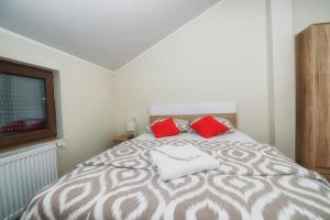 贝尔格莱德Vila Chess的一间卧室配有一张带两个红色枕头的床