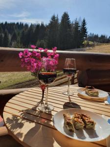 新瓦罗什Zlatar Luxury Chalet - TRACE OF NATURE 2214的一张桌子,上面放着两杯葡萄酒和一些食物