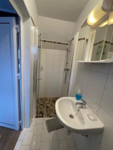 库克斯港Gästehaus zum Surgrund的白色的浴室设有水槽和淋浴。
