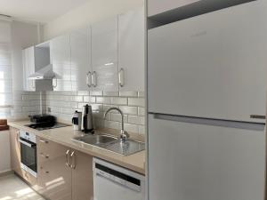 马尔马里斯City Suites的白色的厨房配有水槽和冰箱