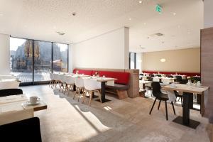 纽伦堡纽伦堡索拉特萨克斯酒店的餐厅设有桌椅和大窗户。