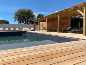 维琪奥港MAISON NEUVE PORTO VECCHIO的一个带木制甲板和凉亭的游泳池