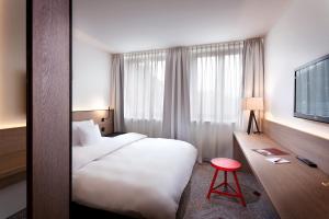 纽伦堡纽伦堡索拉特萨克斯酒店的酒店客房带白色的床和红色凳子