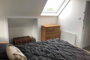 South KessockSeacot Cottage in the heart of the Highlands的一间卧室配有一张床、一个梳妆台和一扇窗户。