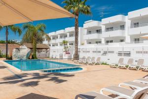阿尔库迪亚港Olive Beach Apartamentos的一个带躺椅的游泳池和一间酒店