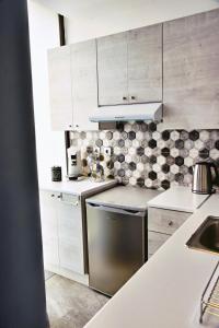 科斯镇Zoes Apartment Kos Town的厨房配有白色橱柜和不锈钢洗碗机。