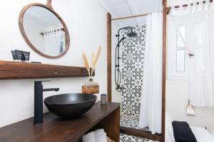 Megali AmmosWhitelist Loft in Mykonos Town的浴室设有木制柜台上的黑碗水槽