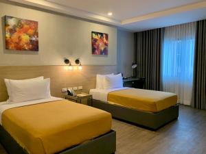 利帕JET Hotel的配有黄色床的酒店客房的两张床