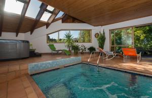 派西亚罗曼提卡木屋酒店的一座带椅子和桌子的别墅内的游泳池