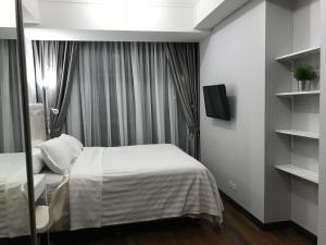 雅加达Luxury 2 BR Condo at Casa Grande Residence - Kasablanka Mall的一间酒店客房,配有一张床和一台电视