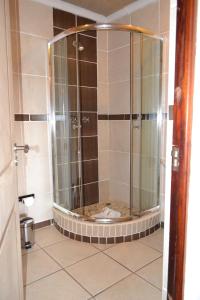 马塞卢Citystay West的浴室里设有玻璃门淋浴