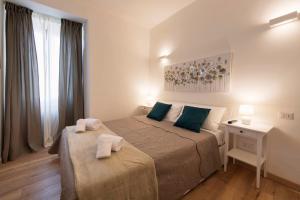 奥维多Nel cuore di Orvieto的一间卧室配有两张带绿色枕头的床