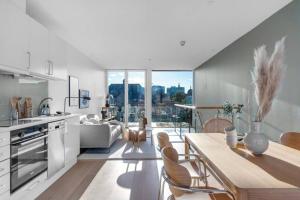 奥斯陆Awardwinning penthouse, Oslo city / Grünerløkka的厨房以及带桌椅的起居室。