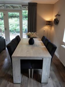 宁斯佩特Bospark Nuwenspete的餐桌、黑色椅子和鲜花桌