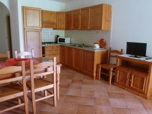 阿科Agritur Maso Fontane的厨房配有木制橱柜、桌子和电视。