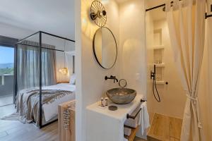 卡利斯托斯Evais Boutique Houses & Luxury Suites的一间带水槽的浴室和一间带一张床的卧室