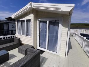 纽基Premium Chalet at Newquay Away Resorts MV7的甲板上有一扇大门的小房子