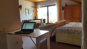 申瓦尔德Ferienhaus Lucia, App.11的一间卧室配有一张床和一张桌子上的笔记本电脑