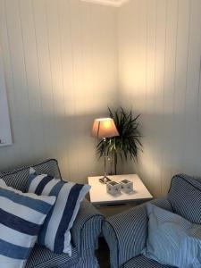 斯塔韦恩Koselig maritim leilighet sentralt i Stavern的客厅配有两张沙发和一张带台灯的桌子