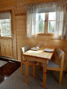 阿克雷里Bakkakot 3 Cozy Cabin In The Woods的窗户间里的一张木桌和椅子