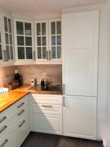 斯塔韦恩Koselig maritim leilighet sentralt i Stavern的白色的厨房配有白色橱柜和水槽