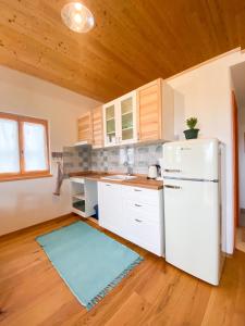 洛帕Arya House的厨房配有白色冰箱和木制天花板