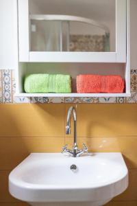 洛帕Arya House的浴室内的盥洗盆,浴室的架子上配有毛巾