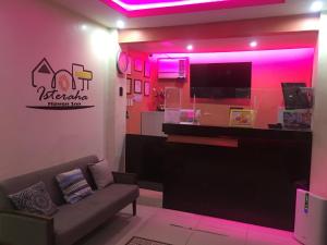 三宝颜Isteraha Haven Inn的带沙发和粉红色灯的客厅